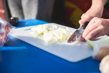 Obraz na płótnie Canvas Hands cutting onion on cutting board