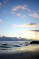 Naklejka na ściany i meble Wunderschöne Wolkenstimmung bei Sonnenaufgang am Meer