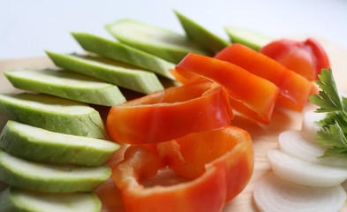 Cooking, cut vegetables on wooden board, red sweet pepper, zucchini, onion, parsley, vegetarian and vegan cuisine, diet