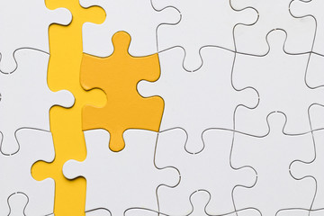 High angle view of yellow puzzle piece arranged with white pieces