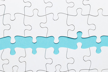 Jigsaw puzzle piece against on blue backdrop