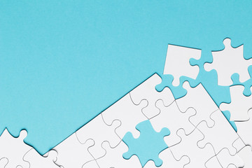 White jigsaw puzzle piece on blue backdrop