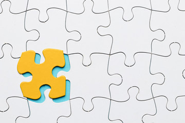 Fototapeta premium White puzzle grid with yellow puzzle piece backdrop