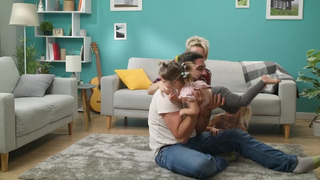 Dad pretends to bite a little daughter while playing a wolf