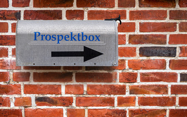 Silberne Prospektbox an einer roten Klinkerwand