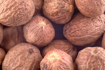 Whole nutmeg spice background texture, copy space, close up. Top view, flat lay