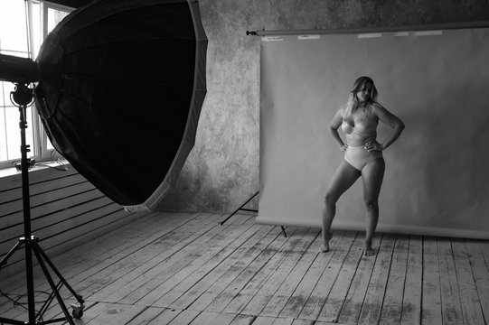 Young beautiful fat girl model posing for a photo shoot in a studio. body positive