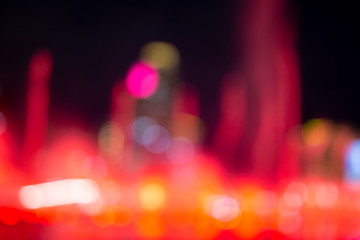 Fountain show with red bokeh color light illumination abstract.