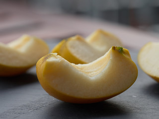 Slices of apple on stone plate on wooden table - breakfast with slices of apple - sliced golden apple