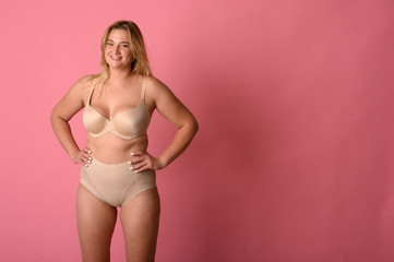 Fototapeta premium attractive chubby girl in underwear on pink background