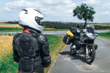 Girl driver portrait, protective equipment, turtle. body armor jacket. Adventure motorbike with side bags. a motorcycle tour journey. view from the back, freedom concept. safety first, safe driving