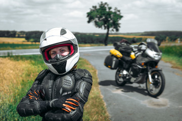 Fototapeta na wymiar Girl driver portrait, protective equipment, turtle. body armor jacket. Adventure motorbike with side bags. a motorcycle tour journey. World travel, freedom concept. safety first, safe driving