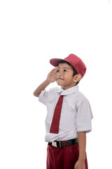 indonesian elementary student wearing uniform giving salute while indonesia flag being raised