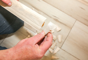 Man is installing the baseboard. Repair works indoors. Renovation in the flat.