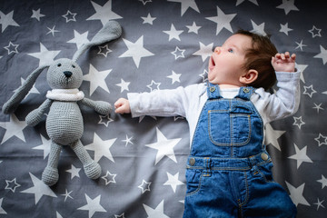 The baby is sleeping with a toy. a small child sleeps by the window, dreaming of a starry sky before going to bed. sleep concept. Top view, flat lay