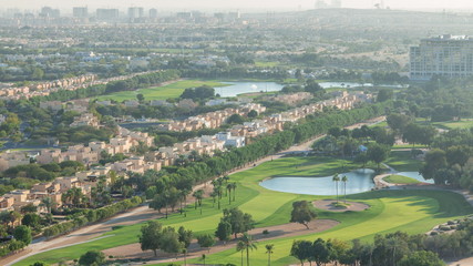 Aerial view to villas and houses with Golf course with green lawn and lakes timelapse