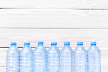 Plastic bottles with pure water on white wooden background top view space for text