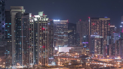 Fototapeta na wymiar Jumeirah lake towers skyscrapers and golf course night timelapse, Dubai, United Arab Emirates