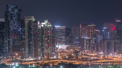 Fototapeta na wymiar Jumeirah lake towers skyscrapers and golf course night timelapse, Dubai, United Arab Emirates