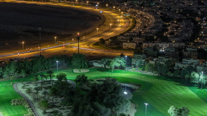 Fototapeta na wymiar Aerial view to villas and houses with Golf course night timelapse