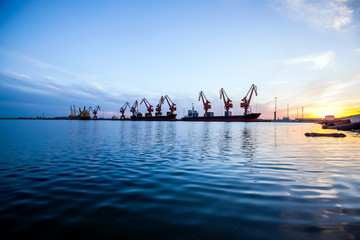 Gantry crane and cargo ship in the evening