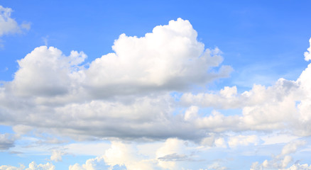 Blue sky background with puffy clouds.
