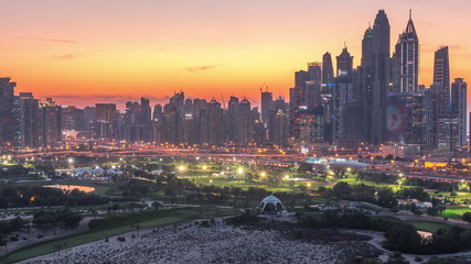 Naklejka premium Dubai Marina skyscrapers and golf course day to night timelapse, Dubai, United Arab Emirates
