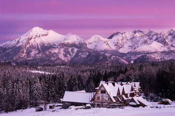 Unusually colorful sunset sky in the mountains with traditional houses.