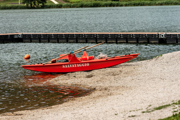 Red and orange lifeguard rowing boat with italian text, salvataggio (rescue). Serraia Lake (Lago della Serraia) Trento province, Trentino Alto Adige, Italy, Europe
