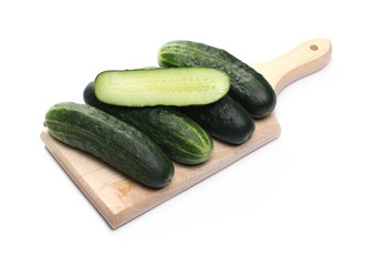 Cucumbers with slice on wooden chopping board isolated on white background