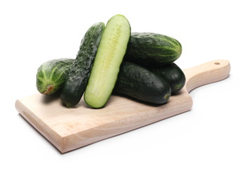 Cucumbers with slice on wooden chopping board isolated on white background