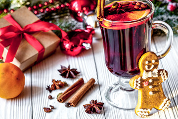 Christmas mulled wine with spices in cup on wooden background