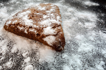 Stone rock covered by white snow and ice crystals. Aerial top view on black isolated background. Winter weather climate natural landscape. Contrast textured mock-up