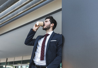 Side view man in suit drinking coffee