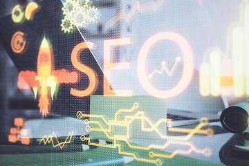 Multi exposure of table with computer and seo drawing hologram. Search optimization concept.