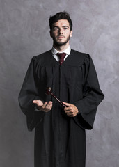 Front view judge in robe with wooden gavel