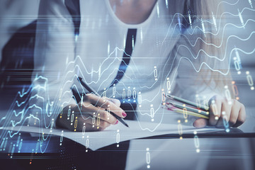 Fototapeta na wymiar Double exposure of hands making notes with forex chart huds. Stock market concept.