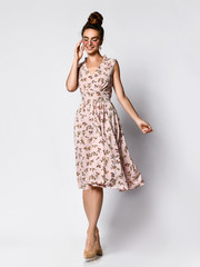 Full length portrait of happy beautiful woman in pink dress posing in studio isolated on white background