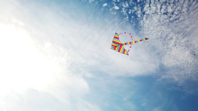 Rainbow kite flying in blue sky