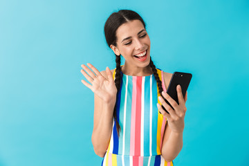 Image of pleased beautiful woman taking selfie photo on cellphone and waving hand