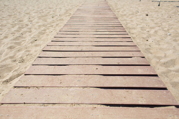 Wooden walking path along sandy shore. beach path