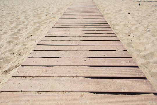Wooden walking path along sandy shore. beach path