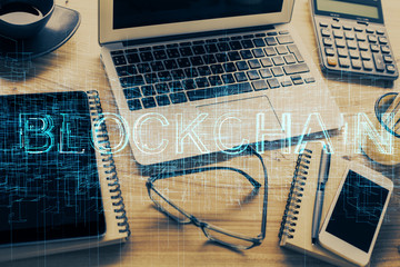 Double exposure of blockchain and crypto economy theme hologram and table with computer background. Concept of bitcoin cryptocurrency.