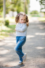 Fototapeta premium Portrait of a little girl with two full-length ponytails while walking