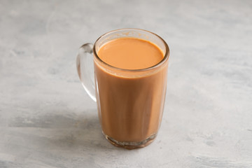 Tea with milk in a mug or popularly known as Teh Tarik on white background, view from side