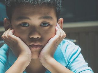 Sad lonely boy, young homeless Asian child high risk of being depressed, bullied and abused....