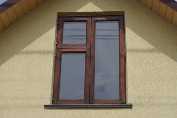 brown wooden window on the gray wall of the house