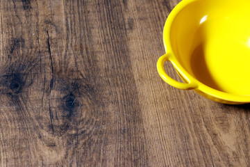 Top view empty yellow bowl on rustic wooden table