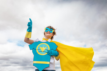 cheerful boy and smiling in superhero costume