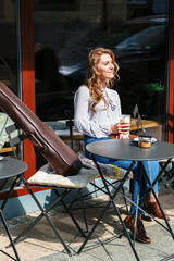 Girl sitting with coffee in hand and violin near